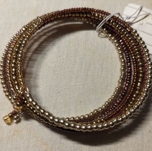A bracelet of small shining golden and silvery beads. Flexible continuous wire.